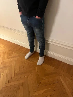 Tiger of Sweden Jeans - Säljer ett par blå slim fit jeans med snygga tvättade detaljer från tiger of sweden. Perfekta för dig som gillar en modern och avslappnad stil.