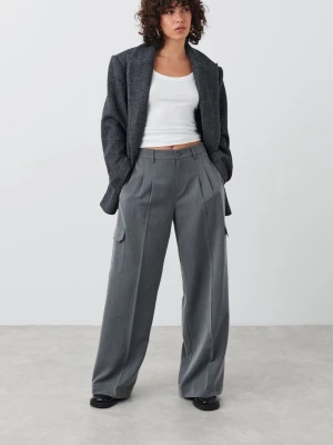 Grå vida cargobyxor från Gina Tricot 34 - Stilrena grå cargobyxor från Gina Tricot med bred passform och pressveck. Byxorna har sidofickor med lock och hällor i midjan. Perfekta för en trendig och avslappnad look. Materialet är mjukt och faller snyggt. Storlek 34. Använt men väldigt bra skick. 