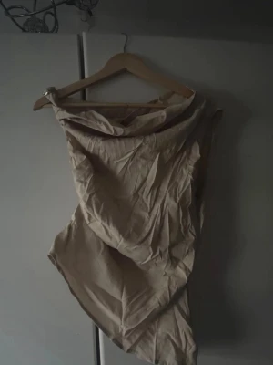 Beige oneshoulder klänning - Trendig beige oneshoulder klänning med asymmetrisk skärning. Klänningen har en enkel och stilren design utan synliga mönster eller detaljer. Perfekt för dig som gillar minimalistisk stil. För fler bilder/information skriv gärna, priset kan justeras 🤗❤️