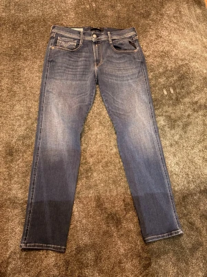 Blå jeans Replay Anbass hyperflex herr 34/30 - Säljer ett par snygga blå jeans från Replay, modell Anbass. Jeansen har klassisk femficksdesign, raka ben och diskreta slitningar framtill. Materialet är mjukt denim med en skön stretch som gör dem riktigt bekväma. Perfekta för dig som gillar stilrena och tidlösa jeans.             Använda en gång så de är helt nya.
