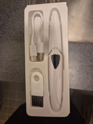 Elektrisk ögonfransböjare vit - Elektrisk ögonfransböjare i vit plast med silverdetaljer. Kommer med USB-laddningskabel och liten rengöringsborste. Smidig design med digital display för enkel användning och långvarig böjning av fransarna.