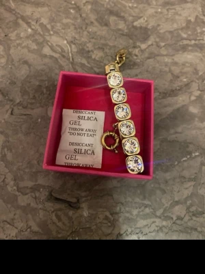 Guldarmband med stora kristaller - Snyggt armband i guldton med stora, runda klara kristaller infattade längs hela bandet. Armbandet har en klassisk låsning och levereras i en rosa ask. Perfekt för dig som gillar att sticka ut med glittriga accessoarer. Från Dyr berg kern köpt på Smycka