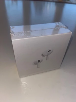 Apple AirPods pro gen 2 - Säljer ett par Apple AirPods Pro i klassisk vit färg. Trådlösa in-ear hörlurar med laddningsetui, stilren och kompakt design. Perfekta för dig som vill ha grymt ljud och smidig anslutning till din iPhone eller andra Apple-enheter.