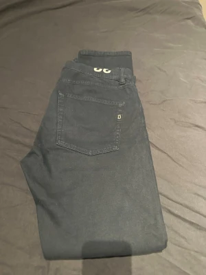 Svarta slim jeans från Dr. Denim - Säljer ett par svarta slim fit jeans från Dondup. Klassisk femficksmodell med diskret logga på bakfickan och smal passform. Jeansen är tillverkade i mjukt bomullsmaterial med lite stretch för extra komfort. Perfekta till en avslappnad streetwear-look. Nästintill helt nya också, 