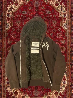 Sällsynt Abercrombie & Fitch hoodie - Säljer denna tvär feta fodrade abercrombie & Fitch zip hoodien! Sjukt sällsynt och förmodligen den enda i denna färg till salu i Sverige!| Storlek L | Mycket bra skick | Längd ≈ 67cm | Bredd ≈ 50cm | Passar 180cm - 195cm | Hör av dig vid fler frågor!