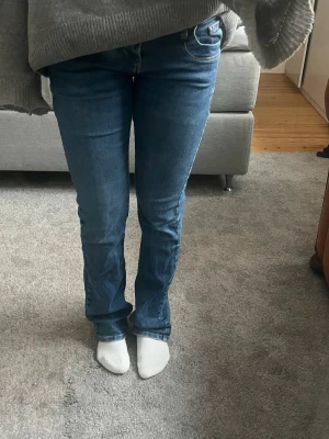 Blå LTB bootcut jeans med låg midja - Säljer ett par klassiska blå LTB bootcut jeans med låg midja och femficksmodell. Jeansen har en snygg tvätt och är tillverkade i stretchigt denimtyg för skön passform. Perfekta till sneakers eller boots. Storlek 26/32