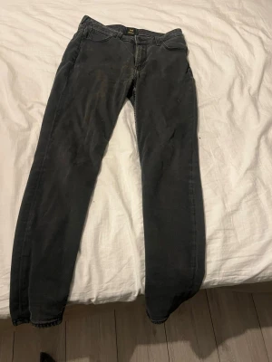 Svarta slim fit jeans - Säljer ett par svarta slim fit jeans med klassisk femficksdesign och dragkedjegylf. Jeansen har en något tvättad look och raka ben. Perfekta till vardagsstilen och passar till det mesta. Materialet är mjukt och stretchigt för extra komfort.