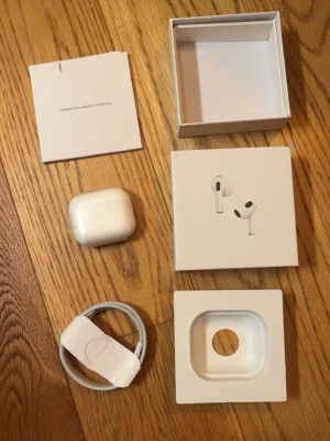 Apple AirPods Pro med laddningsetui - Säljer ett par vita Apple AirPods Pro med trådlöst laddningsetui. Hörlurarna är in-ear och levereras med originalkartong, laddningskabel och dokumentation. Snygg och stilren design i plast, perfekt för dig som vill ha grymt ljud och smidig anslutning till din iPhone. Kommer i oöppnad låda!!
