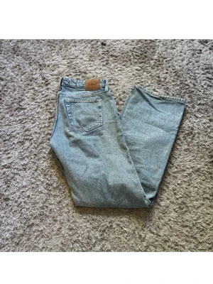Ljusblå raka jeans från Weekday - Säljer ett par klassiska ljusblå jeans från Weekday med rak passform och fem fickor. Säljer då jag ej använder dom, midjan är 26 och längden 32