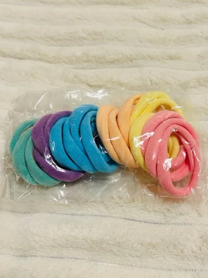 Färgglada mjuka hårsnoddar - Säljer ett set med mjuka hårsnoddar i flera färger: turkos, lila, blå, orange, gul och rosa. Perfekta för att sätta upp håret på ett skonsamt sätt. Tillverkade i elastiskt tygmaterial och levereras i en förpackning med flera snoddar.