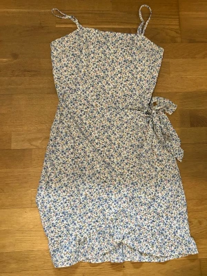 Klänning - Blommig klänning med knytning på sidan 