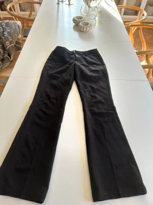 Svarta utsvängda kostymbyxor  - Säljer ett par svarta kostymbyxor med utsvängda ben och klassisk kostymbyxor. Använda fåtal gånger. Inga fläckar, bekväma, och sitter otroligt bra💗