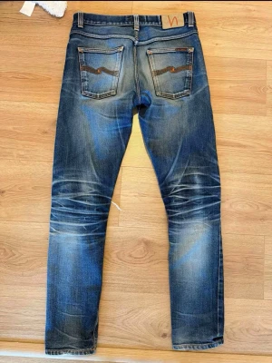 Nudie jeans selvage - Säljer dessa ass feta selvage nudie lean dean.        storlek w32 L34.                                                                 Håll vid knät och i fickan enkelt lagning då nudie jeans ger grattis lagningar. De ger även grattis ner sömning om de är för långa!                                                          model ca170 och 68kg passar även längre folk då man ser på bild att de är vikta längst ner!                                  Mitt pris 2399 priset är EJ HUGET I STEN 🪨🤗