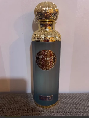 Gissah Imperial parfym 200ml - Lyxig parfym från Gissah Signature Collection i en elegant flaska med gulddetaljer och blågrå kropp. Flaskan rymmer 200 ml och har en dekorativ, rundad guldkork med mönster. Märkt med 'Imperial' och tillverkad i Kuwait.