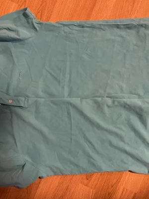 Blå pikétröja från State of Art - Snygg blå pikétröja från State of Art med klassisk krage och knappar framtill. Tröjan har korta ärmar och är tillverkad i mjuk bomull, perfekt för en avslappnad stil. Liten broderad logga på bröstet för en clean look.