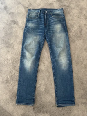 Blå jeans från G-Star RAW - Säljer ett par klassiska blå jeans från G-Star RAW med snyggt slitna detaljer och raka ben.  Skick 9/10, Skriv vid några funderingar 