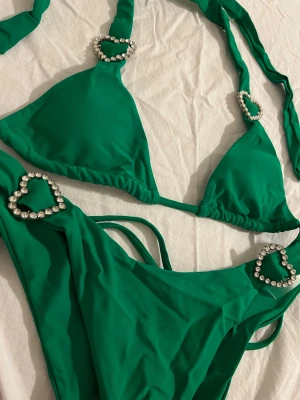 NY! Half Heart / Dollskill grön bikini med hjärtformade detaljer - Ny och plomberad! Grön bikini med ’diamant’ detaljer i hjärtform från Half Heart / Dollskill. Köptes i 2022 men användes aldrig pga fel storlek. Nypris: 290:-