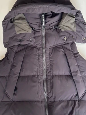 Svart dunväst med huva från G-Star RAW - Snygg svart dunväst från G-Star RAW med stor huva och dragkedja framtill. Aldrig använd, prislapp finns kvar! 