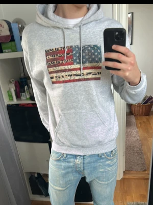 USA flagga hoodie  - Riktigt snygg hoodie med ett unikt Usa-flagga tryck. Hoodien är i en fin ljusgrå färg 