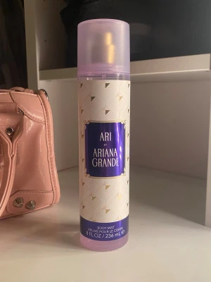 Ari by Ariana Grande Body Mist - Ari by Ariana Grande Body Mist är en kroppsspray i en stilren flaska med lila och guldiga detaljer. Flaskan rymmer 236 ml och har en modern, feminin design med ett genomskinligt lila lock. Perfekt för dig som gillar fräscha och söta dofter. Nästan helfull💜