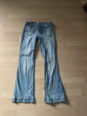 Ljusblå bootcut jeans från Nelly - Superfina, storlek 36 short, använd fåtal gånger