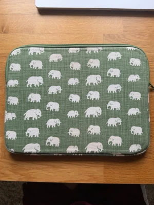 Svensk tenn datorfodral  - Säljer mitt Svensk Tenn datorfodral då den inte passar min nya dator.   Den är för en 13 tums dator och har måtten 32x25. Det är det gröna elefant mönstret som inte längre produceras. Den är i mycket fint skick och har inga fläckar eller skador.   Nypris 1400kr