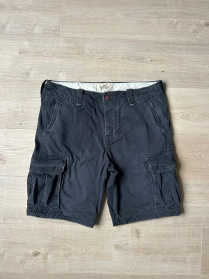 Blåa Hollister Vintage Cargoshorts Storlek W36 - Mycket fina Hollister shorts i blå färg. | Jeansen är i mycket bra skick och sparsamt använda. |  Äkta som allt annat jag säljer! ✅ |  Storlek: W38 | Skick: Mycket Bra Skick | Färg: Blå | Märke: Hollister | Modell: Jeans |   Hör gärna av dig vid frågor så svarar jag så fort jag kan! 😁 |  (SKU - 159)