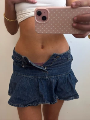 Lågmidjad mörkblå jeanskjol med volang  - Såå fin lågmidjad mörkblå jeanskjol med volang! Midjemått rakt över: 35 längd 30. Jag är 168 och det är mina bilder, köp via köp nu direkt eller Swish, kvar tills markerad som såld 💖 