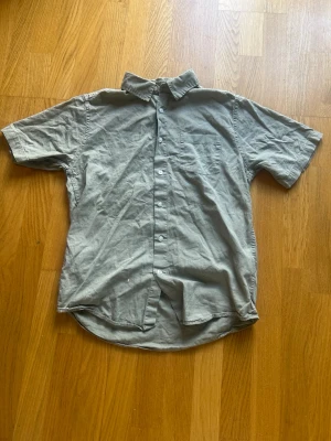 Grön kortärmad skjorta från Lager 157 -  enkel och stilren grön skjorta med korta ärmar. Skjortan en bröstficka fram. Perfekt till sommaren och lätt att matcha med olika outfits.
