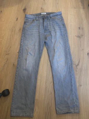 Ljusblå raka jeans från Jack & Jones  - Säljer ett par ljusblå jeans från Jack & Jones  med rak passform och klassisk femficksdesign. Jeansen har normal midja och är tillverkade i denim av bomull. Perfekta för en avslappnad och trendig look.