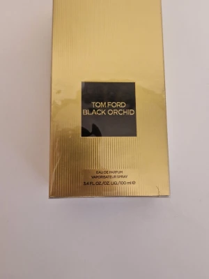 Tom Ford Black Orchid EdP 100 ml - Tom Ford Black Orchid Eau de Parfum i en lyxig guldfärgad förpackning med svart etikett. Flaskan rymmer 100 ml och doften är känd för sin djupa, sensuella karaktär. Perfekt för dig som gillar exklusiva och unika parfymer.