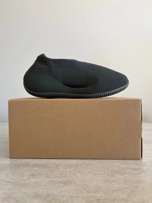 Adidas Yeezy Knit Runner svart - Säljer ett par Adidas Yeezy Knit Runner i svart. Skorna har en unik, strömlinjeformad design med stickad ovandel och rundad tå. Yttersulan är räfflad för extra grepp och hela skon är tillverkad i ett mjukt, flexibelt material som formar sig efter foten.