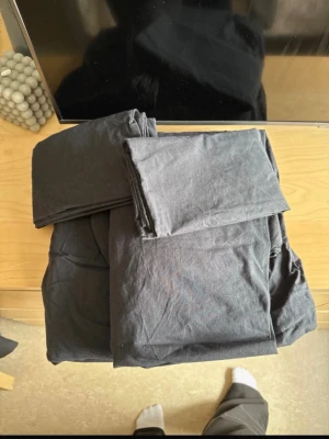 Svart påslakanset i bomull - Säljer ett svart påslakanset i mjuk bomull. Setet består av ett påslakan och ett eller flera örngott, perfekt för dig som vill ha en stilren och enkel look i sovrummet. Materialet är tunt och smidigt, och färgen är neutral och lätt att matcha. Storleken är 150x200 på båda sätten och 50x60 på örngotten 