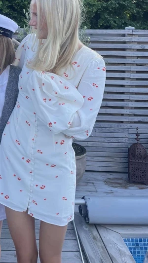 Adoore klänning - Söt vit kortklänning med små röda blommor och puffärm. Endast använd en gång!!! Storlek 34💕💕💕