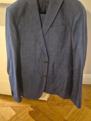 Blå kostym från J.Lindeberg - Hel kostym strl 48. Använd ett fåtal gånger. Ej fodrad, bra sommarkostym