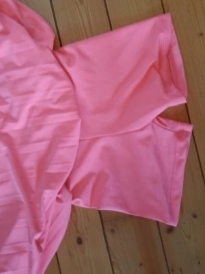 Rosa skort från Nike med plissering - Säljer en snygg rosa skort från Nike med plisserad kjoldel och inbyggda shorts. Skorten har bred resår i midjan och är tillverkad i ett stretchigt funktionsmaterial som passar perfekt för en aktiv livsstil. Nike-logga framtill på linningen.