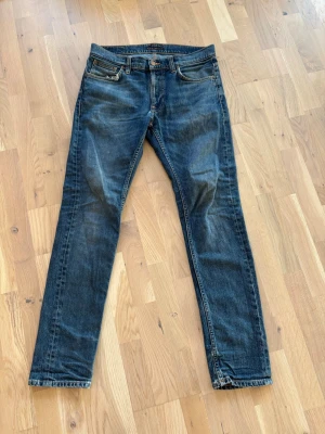 Mörkblå slim fit jeans från Nudie - Snygga mörkblå slim fit jeans från Nudie. Väldigt använda därav priset. Dock sitter helt perfekt och varit mina favorit jeans länge. Skriv om ni har frågor!!! Pris ej hugget i sten.