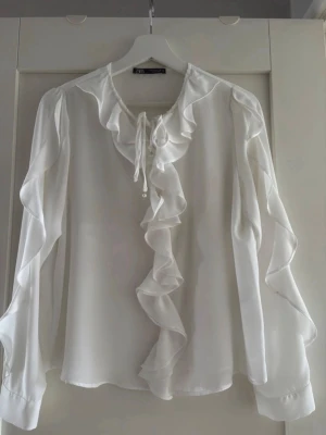 Vit volangblus från Zara - Vit blus från Zara med volangdetaljer. Fint skick. Storlek S🤍Redo att skickas direkt📦