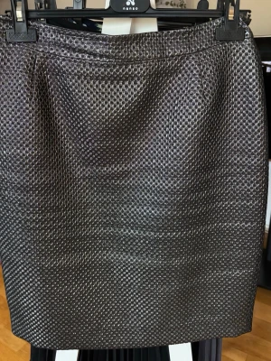 Mönstrad silverkjol från Zoul Edition - Säljer en snygg kortkjol från Zoul Edition i silver med ett diskret geometriskt mönster. Kjolen har en rak passform och är tillverkad i ett glansigt material som ger en cool look. Perfekt för dig som vill sticka ut lite extra.