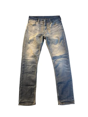 Blå raka jeans från Levi's | 511 | W32 L32  - Klassiska blå jeans från Levi's med rak passform och fem fickor. Jeansen har en snygg tvättad look med slitningar och kontrastsömmar. Mått finns på bilderna! 