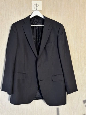 Oscar Jacobson kostym storlek 50 - Klassisk mörkblå kostym från Oscar Jacobson i ull som tillverkats av Cerruti i Italien. Kostymen är i storlek 50  och heter Gilbert suit  