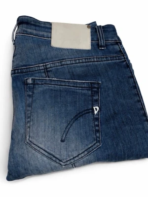 Blå slim fit jeans från Donup - Snygga blå slim fit jeans från Donup med klassisk femficksdesign och diskreta slitningar framtill. Jeansen har en ljus tvätt och vita kontrastsömmar samt en liten D-detalj på bakfickan. Tillverkade i mjuk denim med stretch för extra komfort.