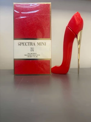 Spectra Mini No 078 parfym - Unik parfym i en röd stilettformad flaska med gulddetaljer. Spectra Mini No 078 Eau de Parfum, 30 ml. Förpackningen är röd med guldkanter och vit etikett. Flaskan är tillverkad i glas och plast, designad för att sticka ut på hyllan. Doften är en inspirerad version av parfymen Very Good Girl från Carolina Herrera.
