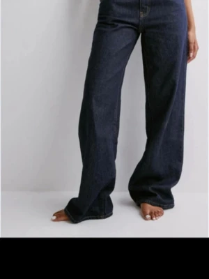 Mörkblåa vida jeans med låg midja - Säljer ett par mörkblåa jeans med låg midja och vida ben. 