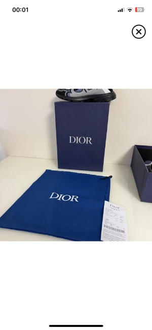 Dior B22 sneakers svart/vit - Säljer ett par Dior B22 sneakers i svart och vitt med gråa och blå detaljer. Skorna har chunky sula och mesh- samt läderpaneler för en modern look. Klassisk snörning och tydlig Dior-logga på sidan. Kommer med originalkartong och dustbag.