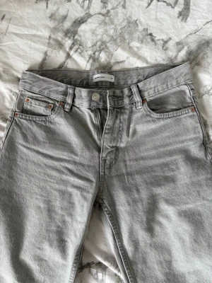Grå raka jeans från Gina tricot  - Snygga grå jeans från Gina tricot med klassisk femficksmodell och raka ben. Tillverkade i denim med en mjuk tvättad finish som ger en avslappnad look.