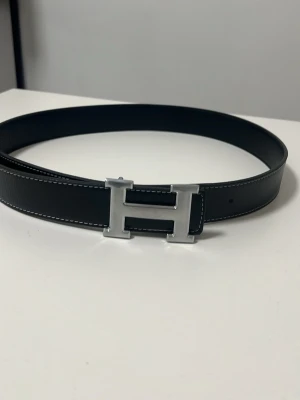 Svart bälte med h spänne - Snyggt h bälte. 105 CM långt. Priset kan diskuteras 