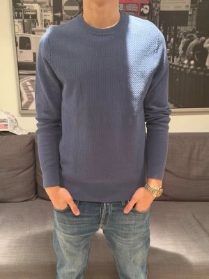 Blå strukturerad tröja - Säljer en stilren blå tröja från j.lindberg. Perfekt för dig som gillar enkel men snygg design.