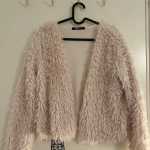 Crèmefärgad/Beige teddyjacka från Gina Tricot - Mysig crèmefärgad/beige teddyjacka från Gina Tricot med långärmad design i storlek S. Jackan har en fluffig textur som ger en trendig look. Är i mycket bra skick och passar perfekt till våren. 