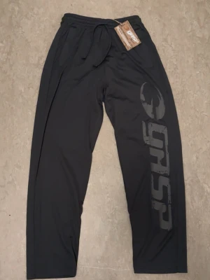 Gråa träningsbyxor från GASP - Säljer ett par helt oanvända svarta träningsbyxor från GASP. Det har ett stort GASP tryck längs ena benet. Det är tillverkade i ett luftigt och bekvämt material som passar perfekt för gym eller annan träning. Om du har några mer frågor så hjälper jag vänligen till. De skickas ut samma dag eller dagen efter som de beställs📦.